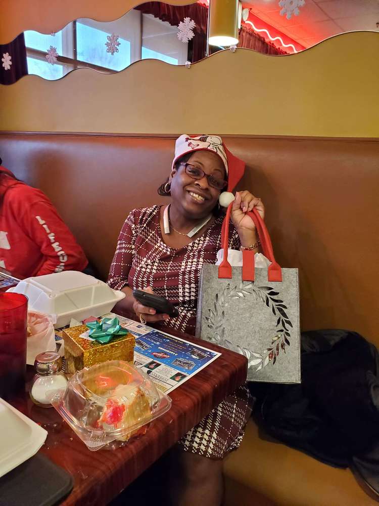 Woman holding gift bag and smiling for camera