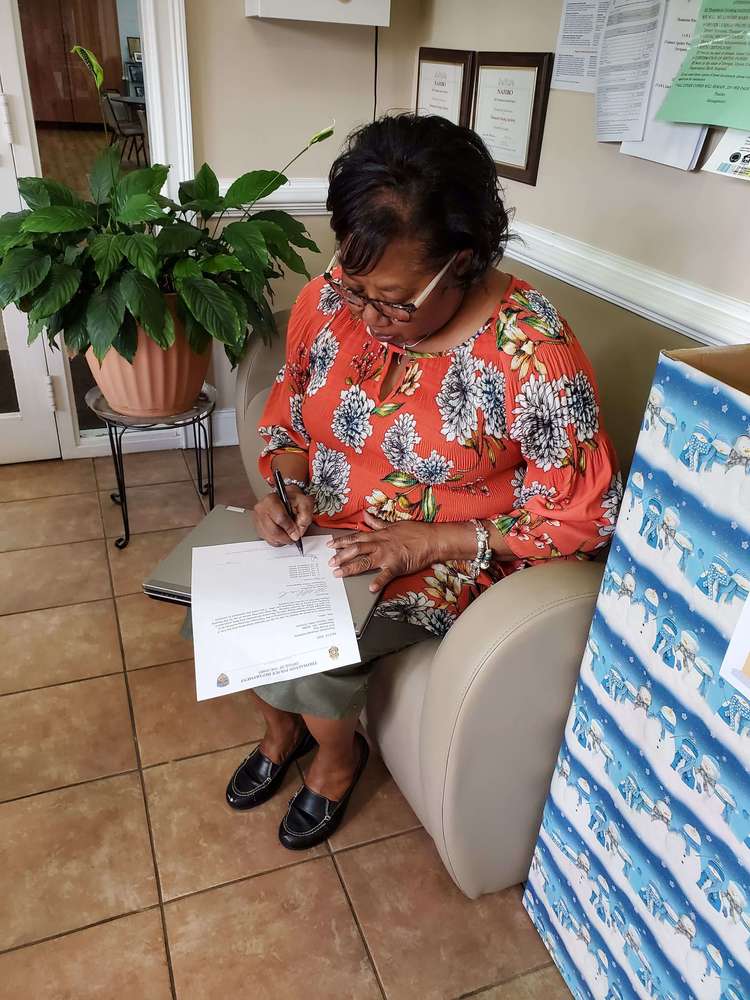 THA Executive Director Patricia Allen signing paperwork