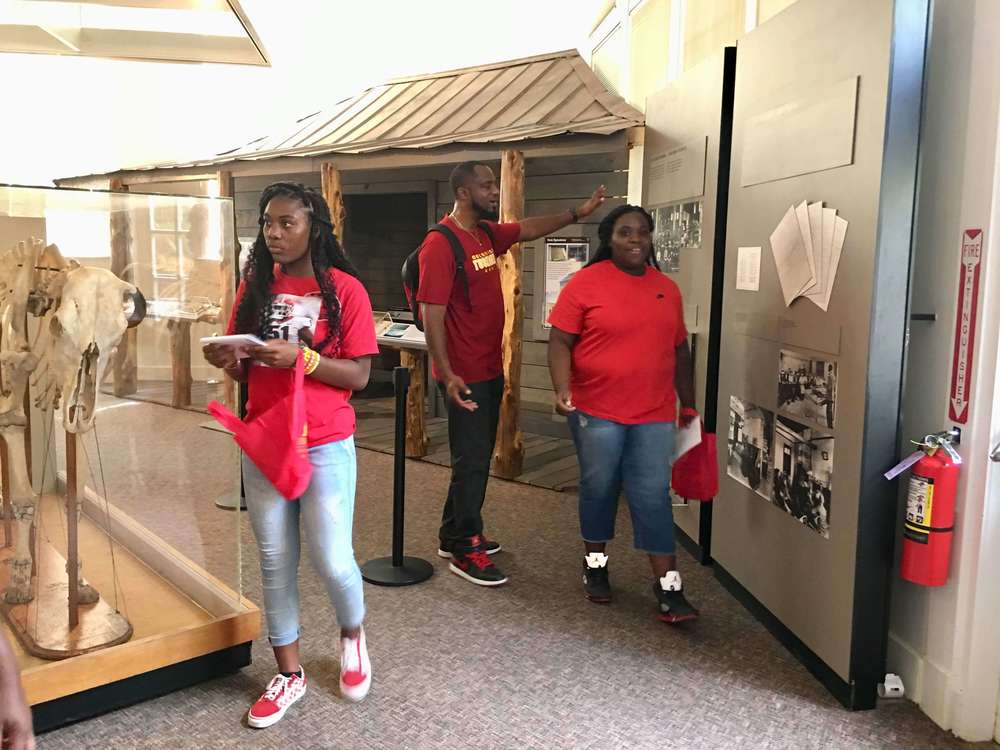 Three students viewing museum displays