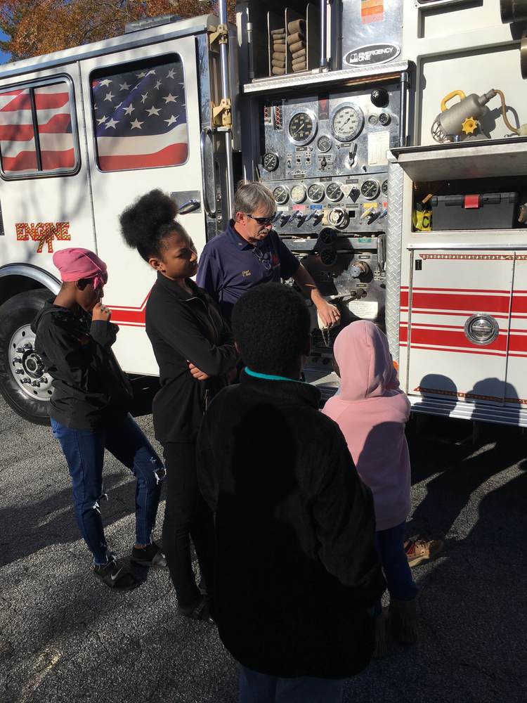 Fireman showing fire truck to kids