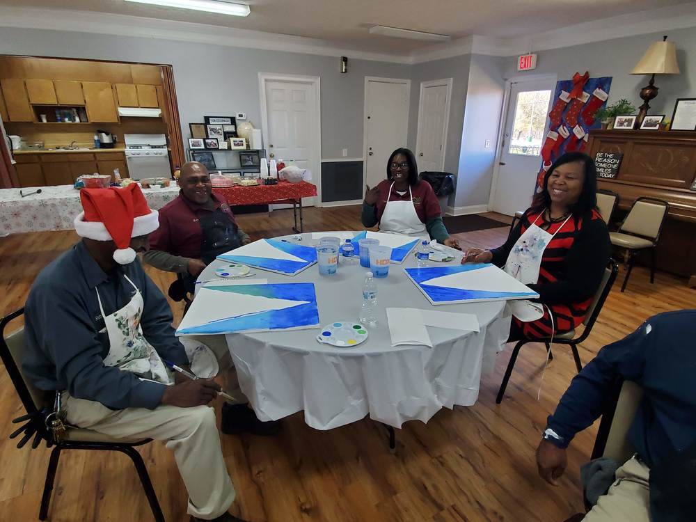 Employees around a table painting