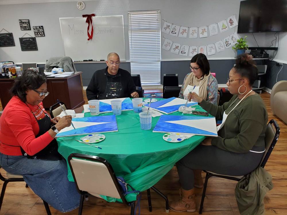 Four staff members working on their paintings