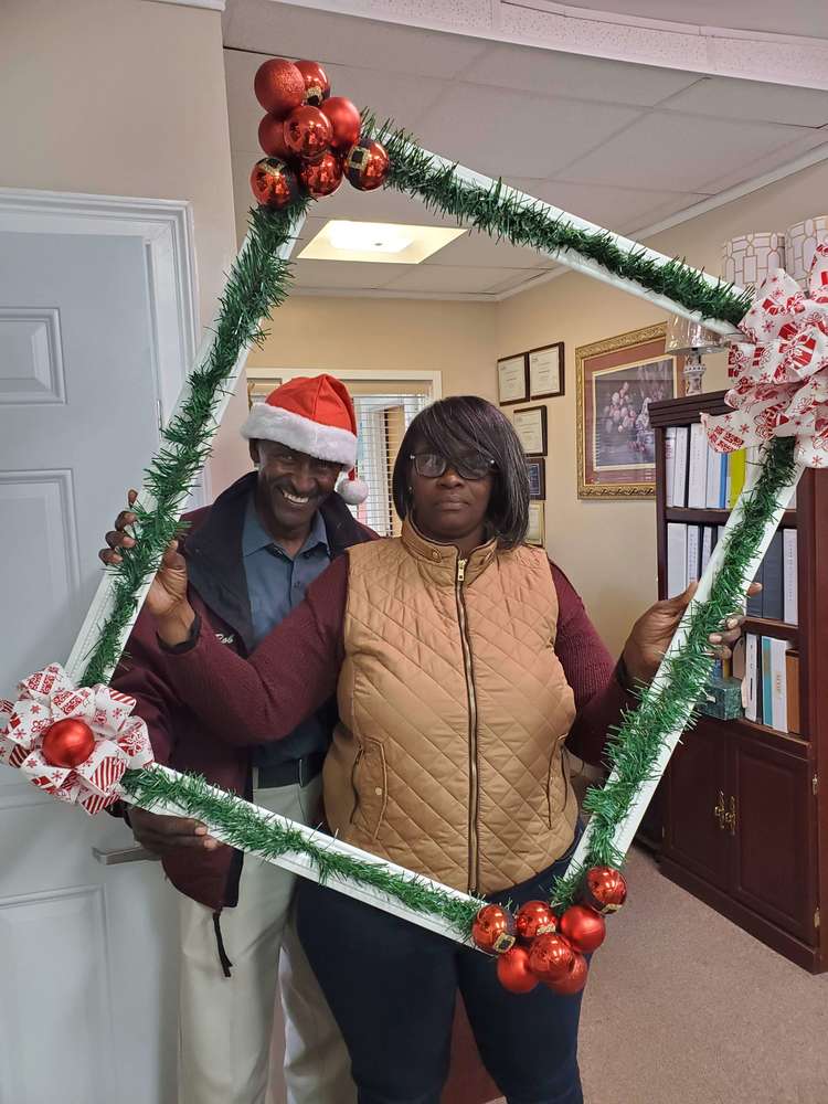 2 staff members posing with frame prop