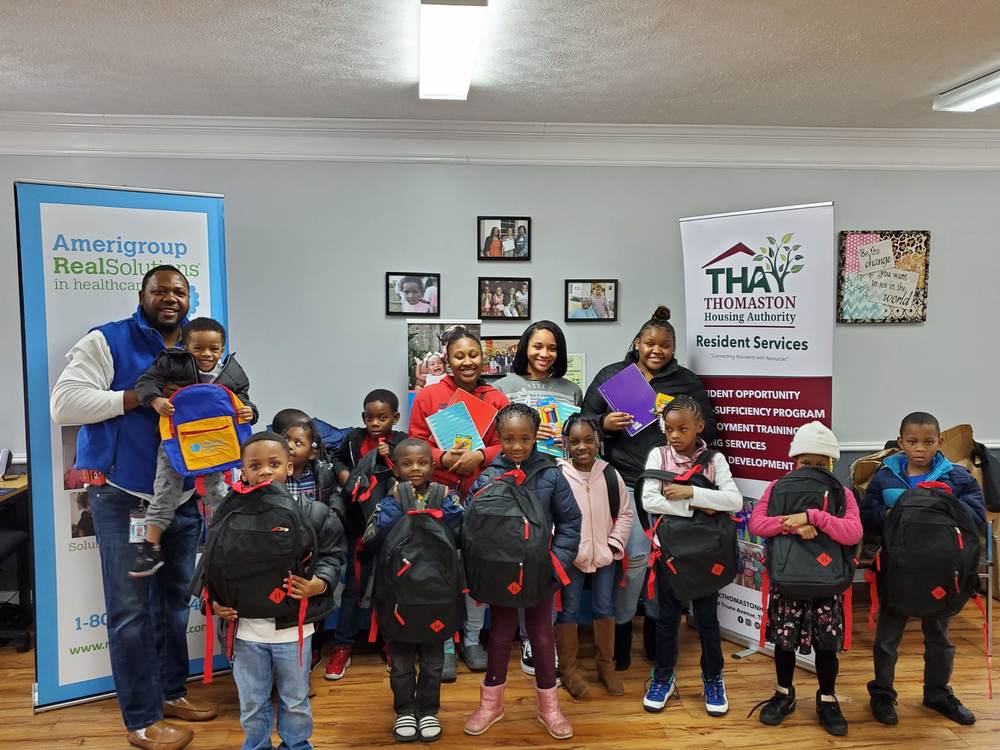 Group photo of kids holding their backpacks