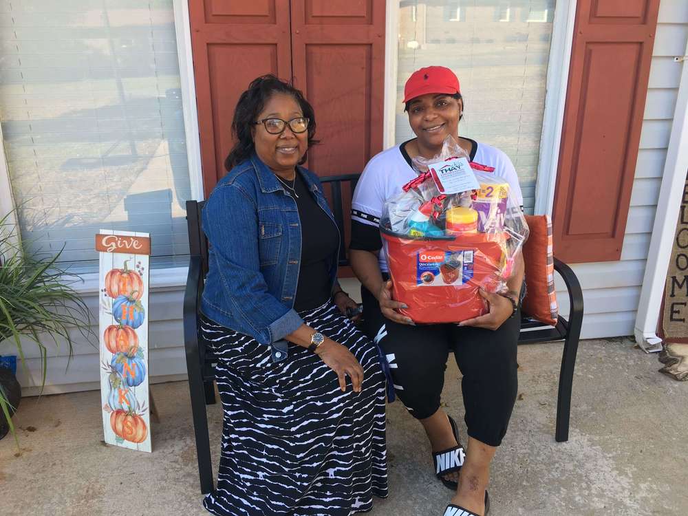 Diva Thomas sitting on porch with gift basket