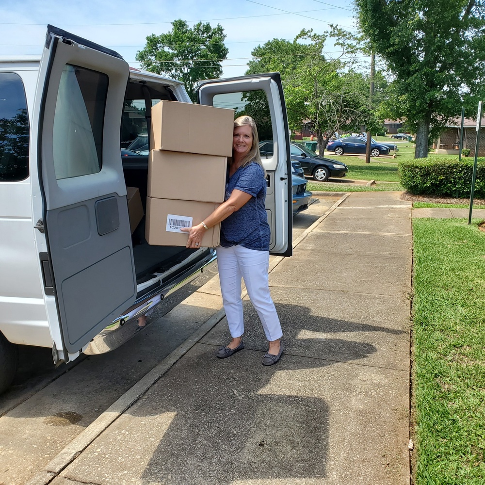 Woman unloading boxes from van