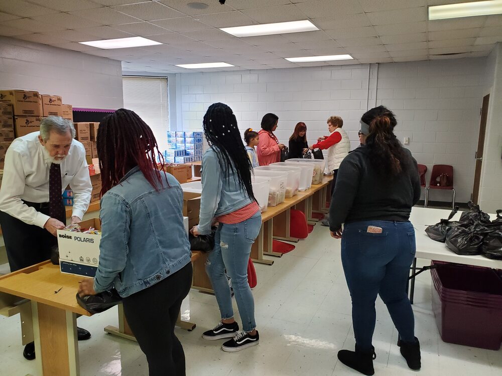 Volunteers working on assembly line packing food bags