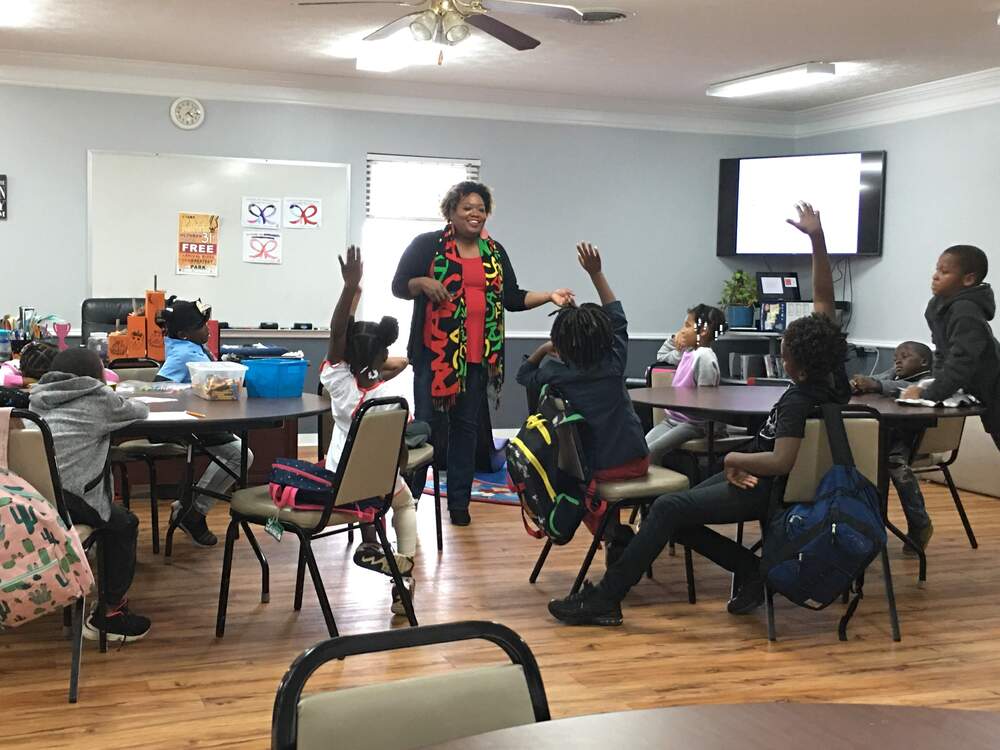 Kids answering red ribbon week questions with hands up