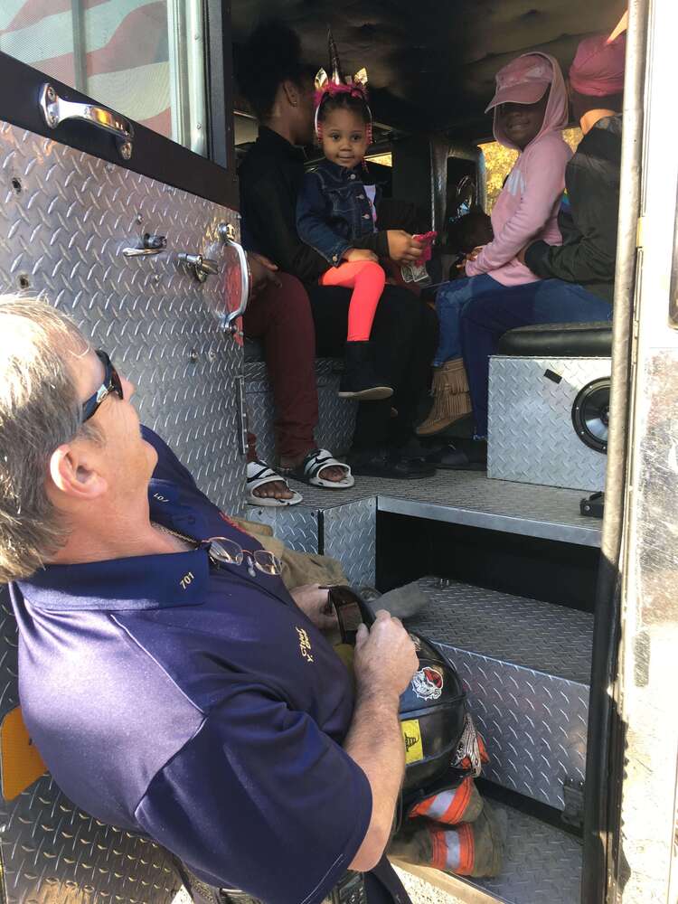 Fireman looking up at kids in firetruck cab