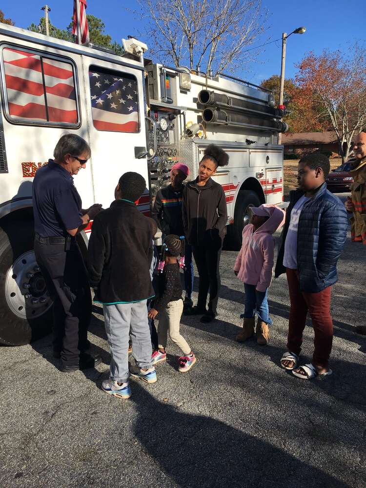 Fireman explaining fire truck parts to kids