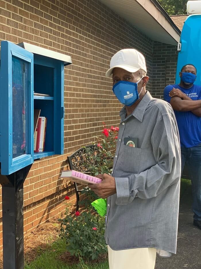 man stocking new little library